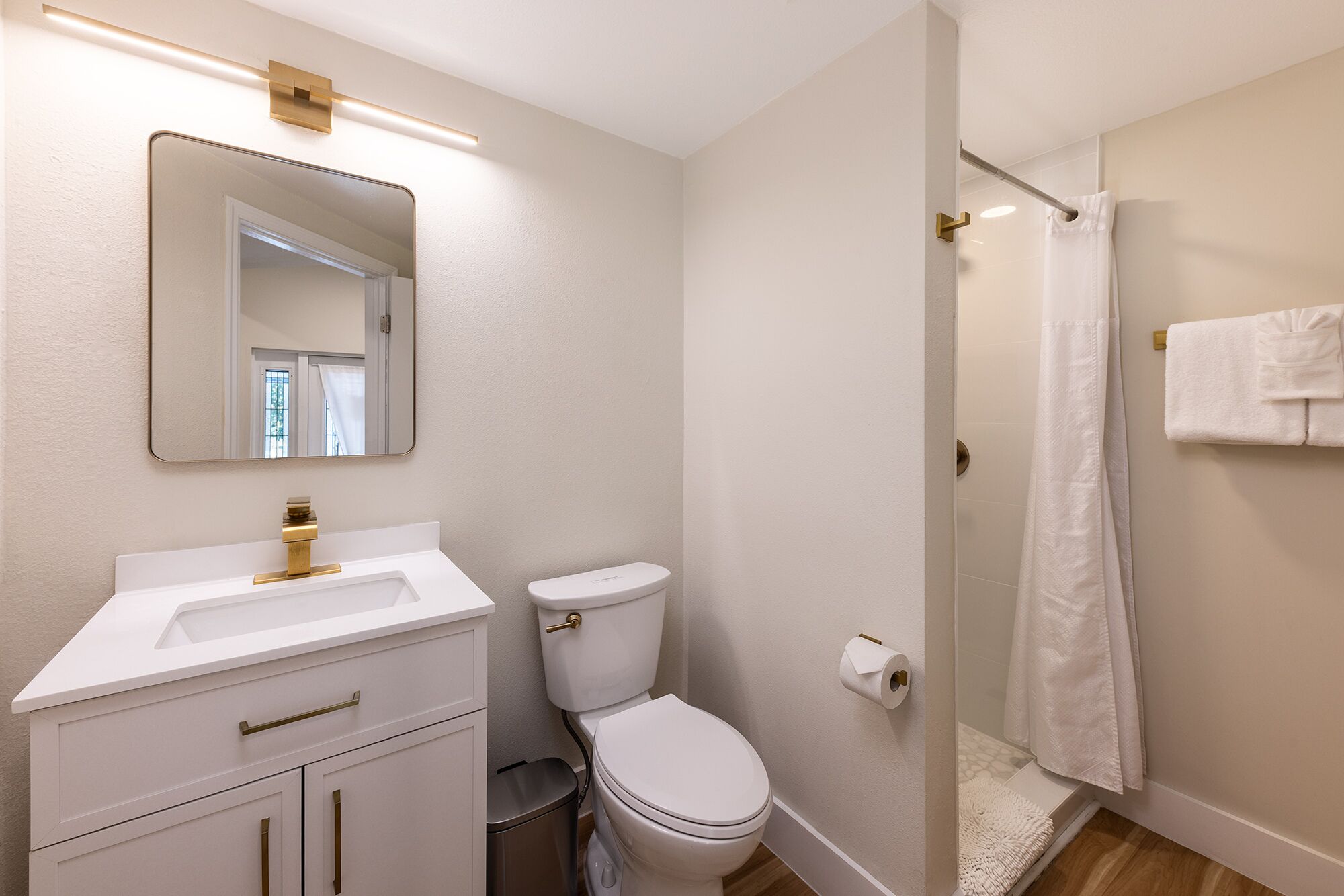 A bathroom with a white sink, toilet, and shower curtain.