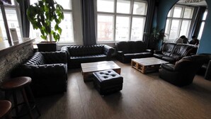 A cozy living room with leather sofas, a coffee table, and a potted plant.