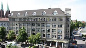 Ein großes, mehrgeschossiges Gebäude mit einer symmetrischen Fassade, zahlreichen Fenstern und einem flachen Dach mit Dachgauben.