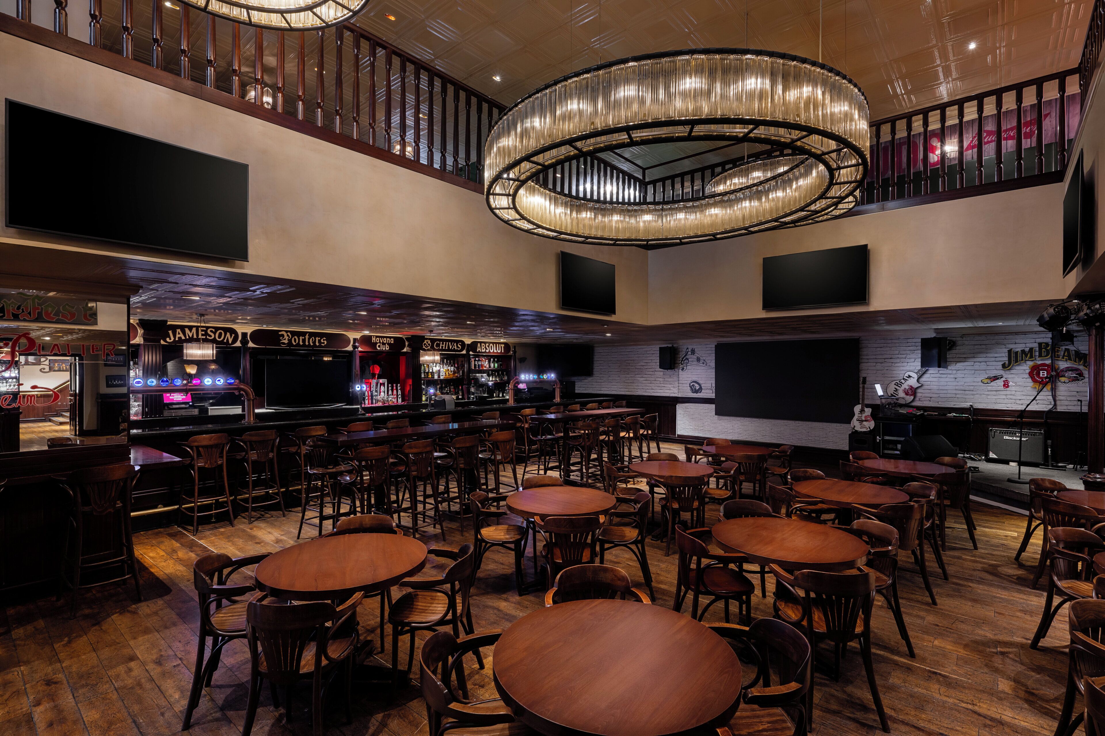 Un'ampia zona bar con varie disposizioni dei posti a sedere e un moderno lampadario.