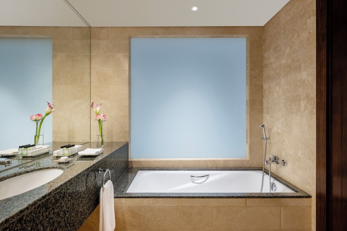 Ein modernes Badezimmer mit zwei Waschbecken, einer großzügigen Badewanne und einer Dusche.