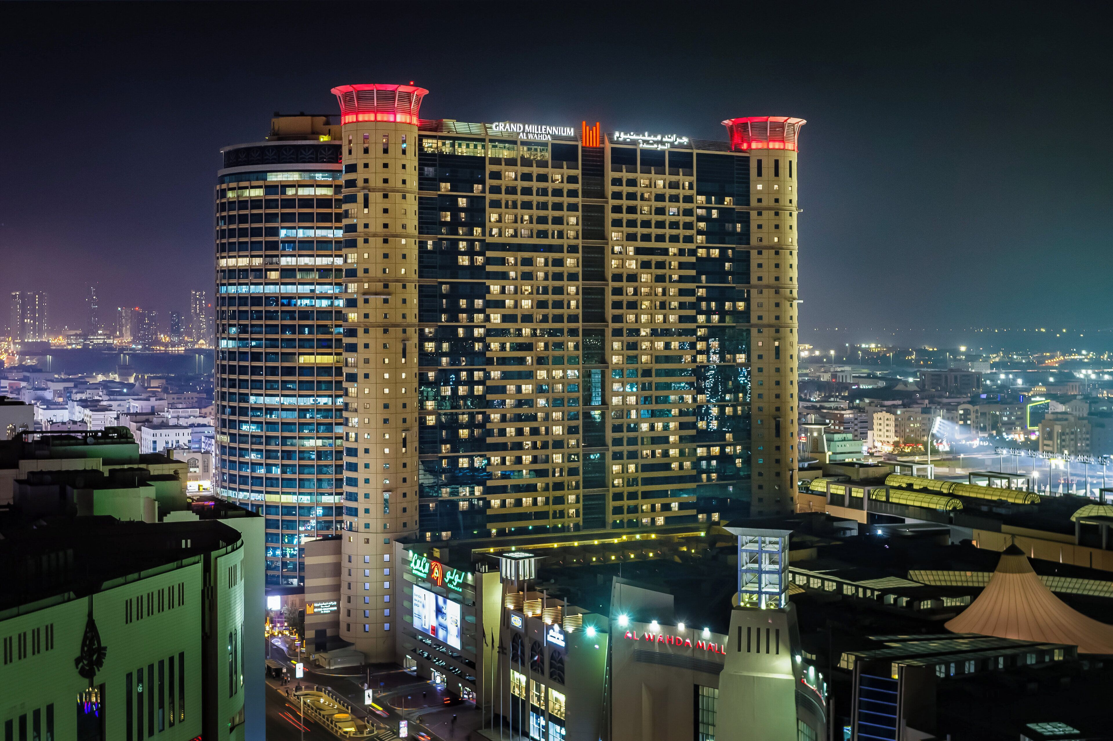 A high-rise hotel with multiple floors, illuminated windows, and a prominent sign at the top.