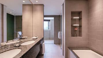 Une salle de bain moderne avec deux lavabos, une douche et une baignoire.