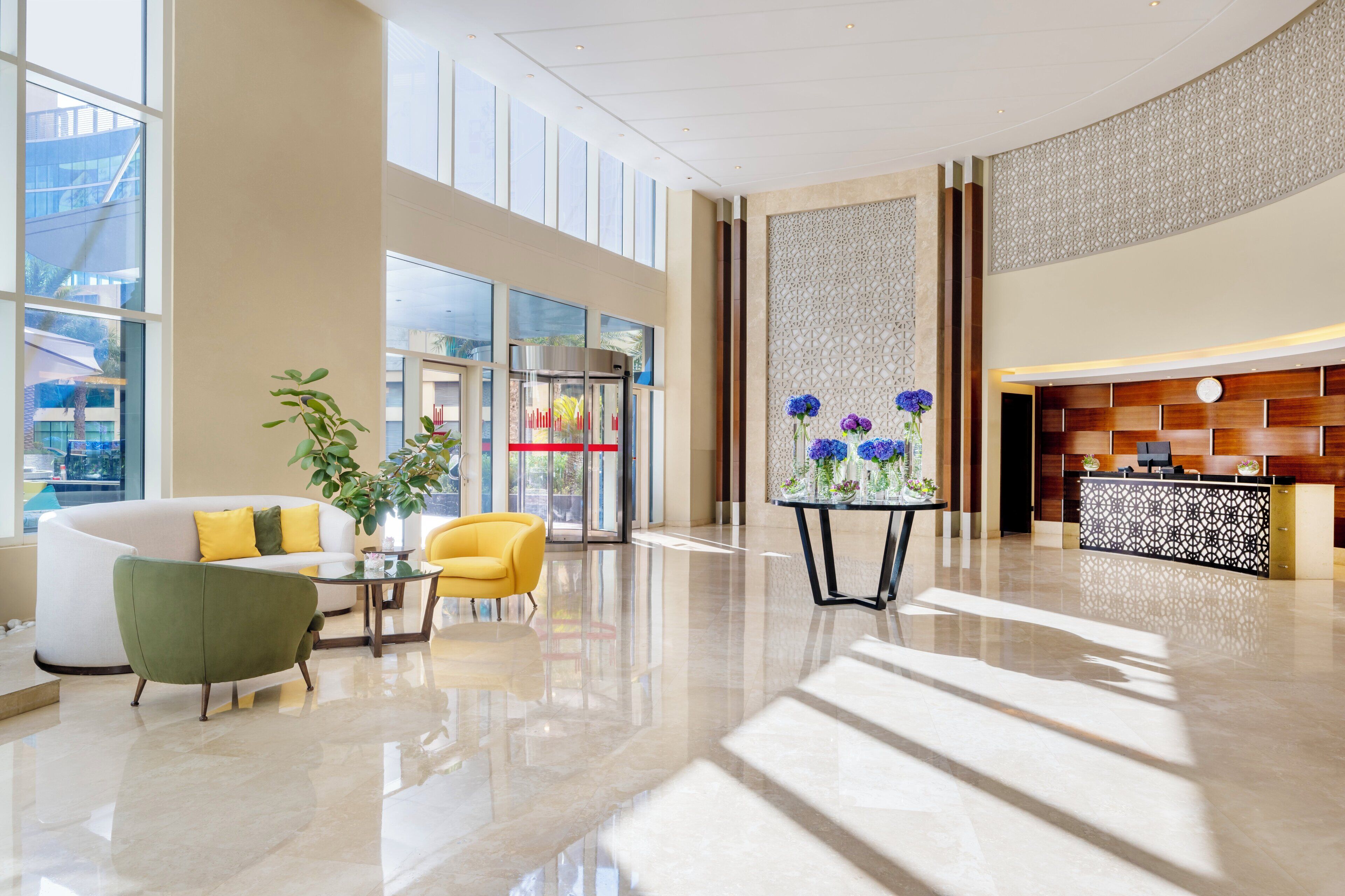Una hall moderna con reception, area salotto e ampie finestre.