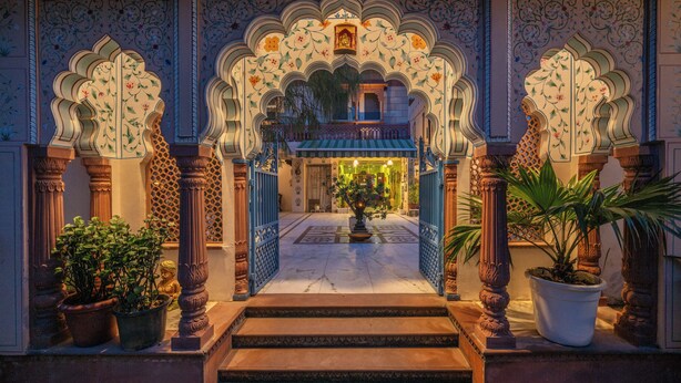 An ornate entrance with detailed arches and columns, leading to a well-lit interior. - Suryaa Villa - A City Centre Hotel (Jaipur)