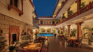 A courtyard with a pool, outdoor seating, and potted plants. - Suryaa Villa - A City Centre Hotel (Jaipur)