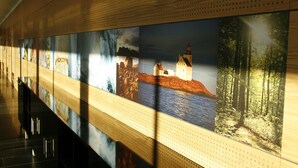A corridor with a series of framed pictures on the wall. - Hotell Montebello (Oslo)