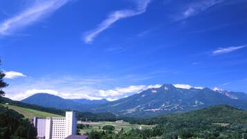 A mountainous landscape with a large building and a smaller structure in the foreground.