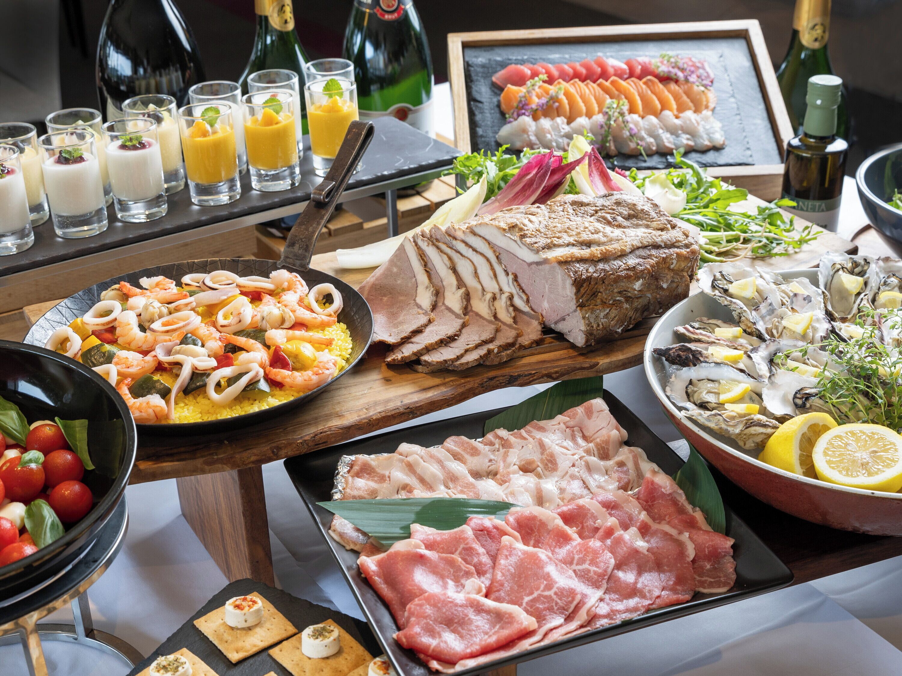 A variety of food items including seafood, meats, and a selection of drinks.