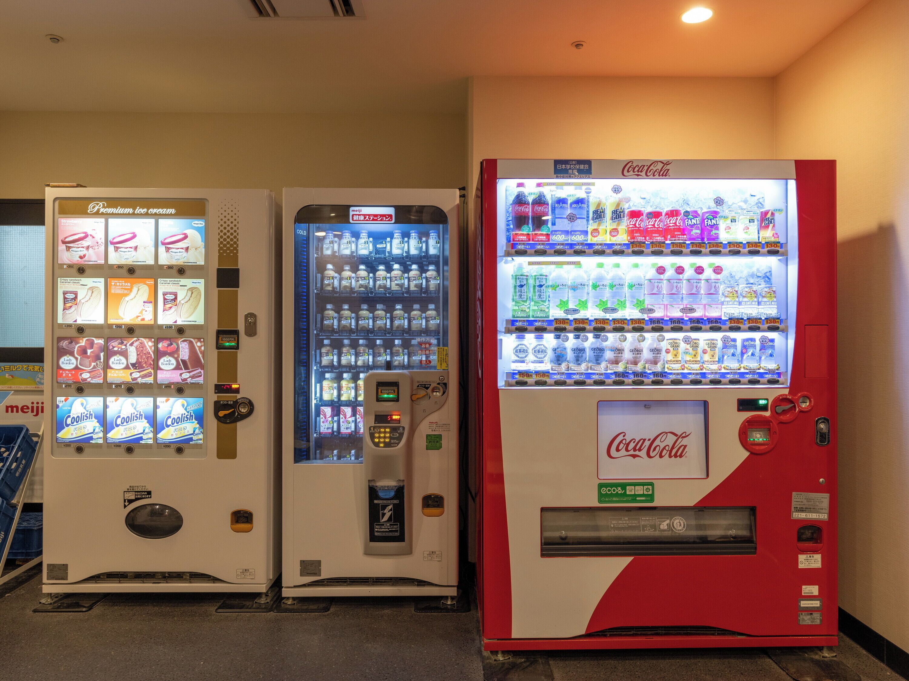 Drei Automaten mit verschiedenen Getränken und Snacks.