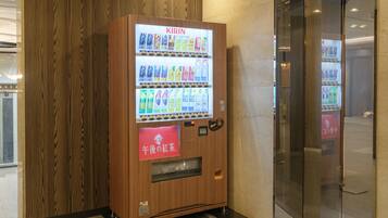 A vending machine with a variety of drinks and a red sign with Japanese text.