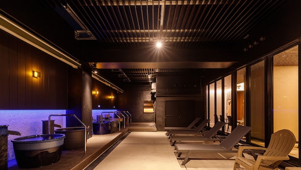 Un área de spa con jacuzzis, sillones de descanso y piso de baldosas.