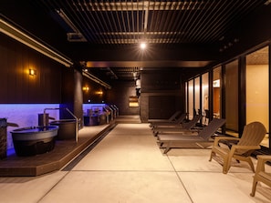 A spa area with hot tubs, lounge chairs, and a tiled floor. - APA Hotel Stay Toyama (Toyama)