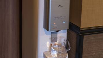 Un dispensador de agua con una jarra transparente incorporada, que cuenta con un panel de control con varias opciones.