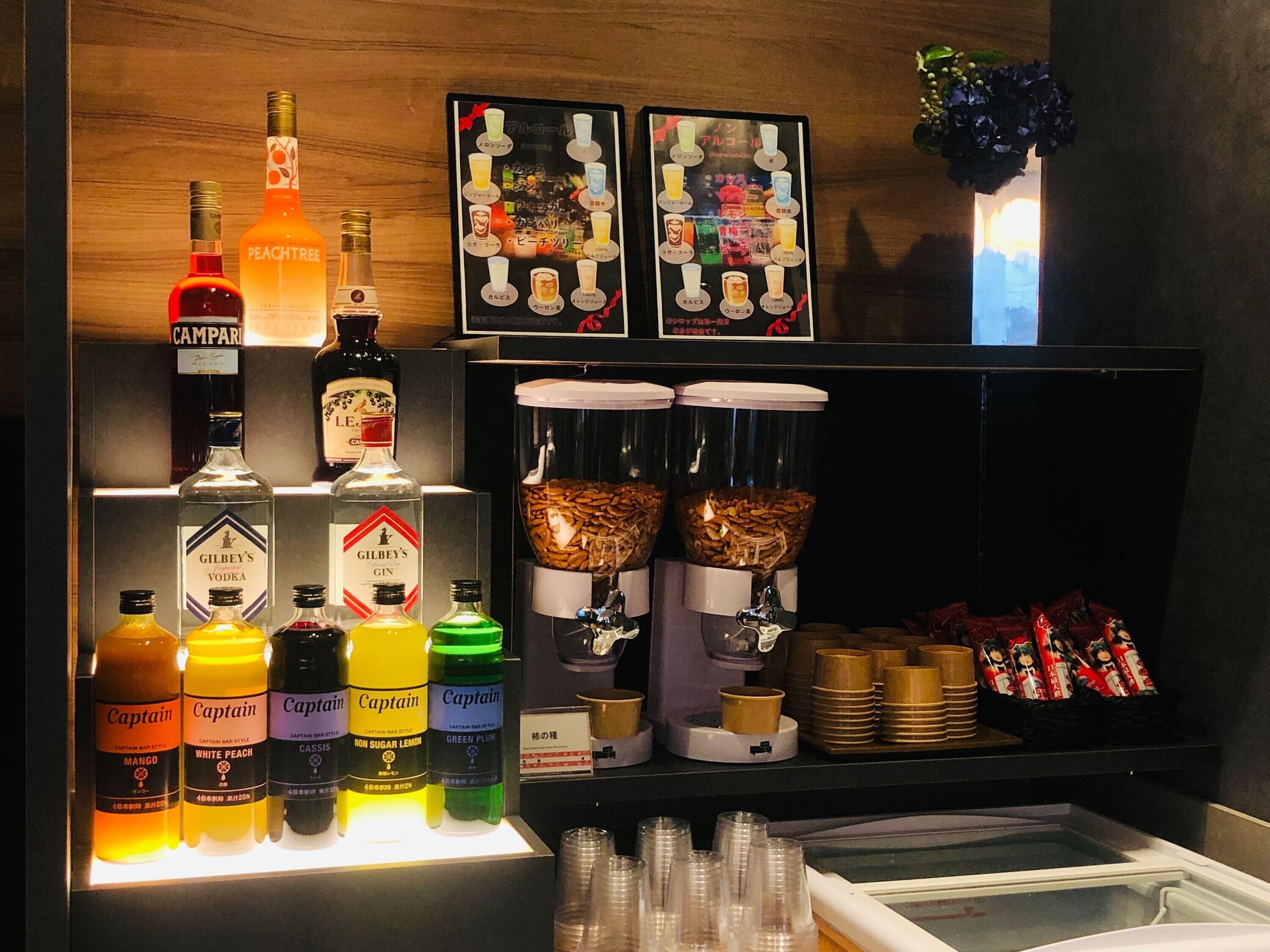 A bar area with various liquor bottles, a menu board, and a coffee machine.