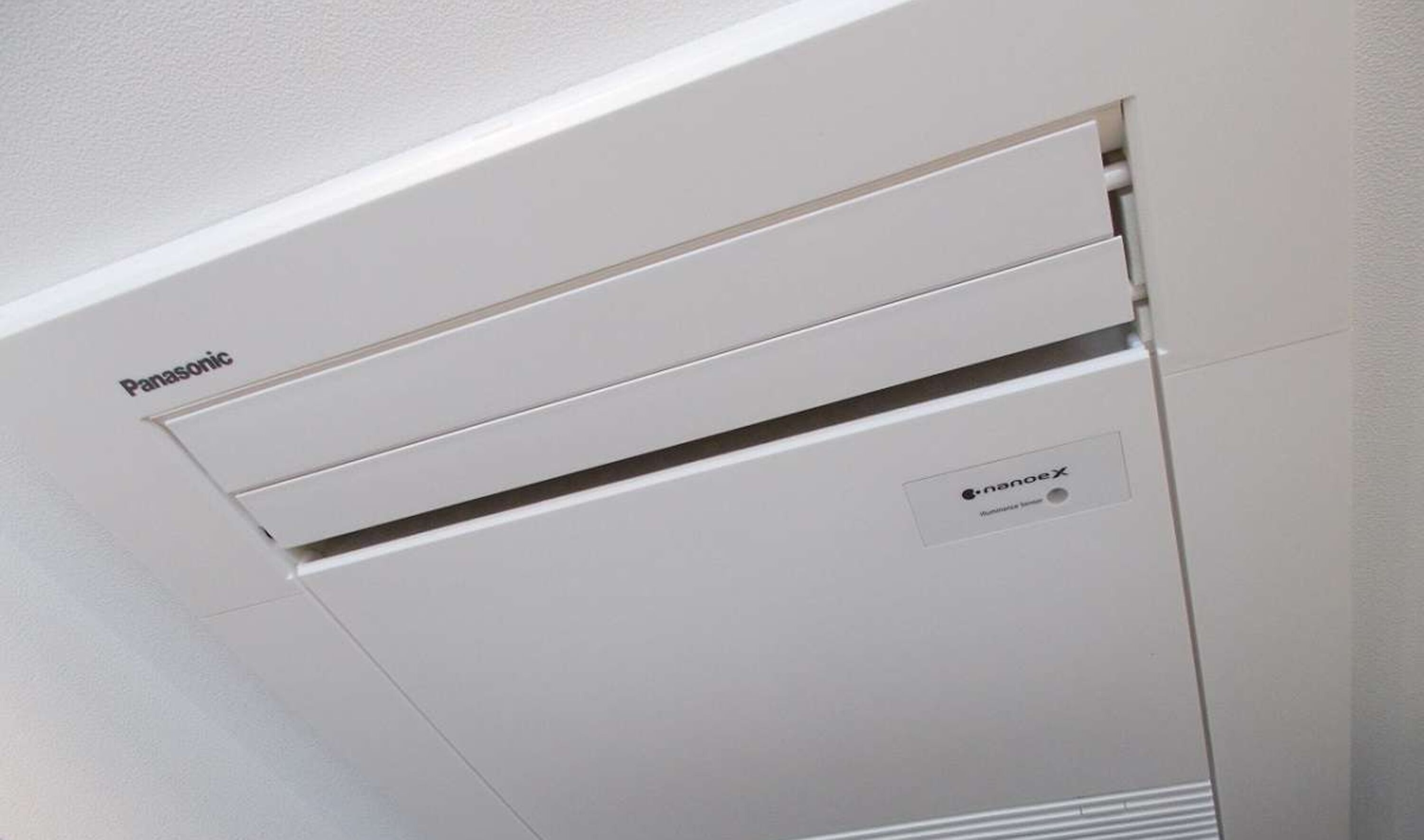 Un equipo de aire acondicionado Panasonic blanco con etiqueta nanoX en el lateral.