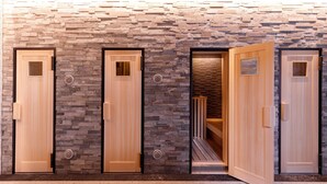 Una hilera de puertas de madera con detalles de pared de piedra, techo de madera y piso de baldosas.