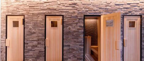 A row of wooden doors with stone wall accents, a wooden ceiling, and a tiled floor.