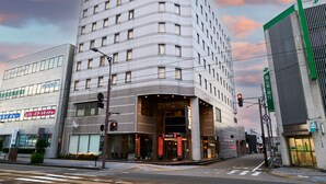 Een modern hotel met een hoingang, meerdere verdiepingen en een zichtbaar restaurantsbord.