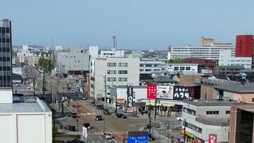 A city street with buildings, a road, and a blue directional sign.