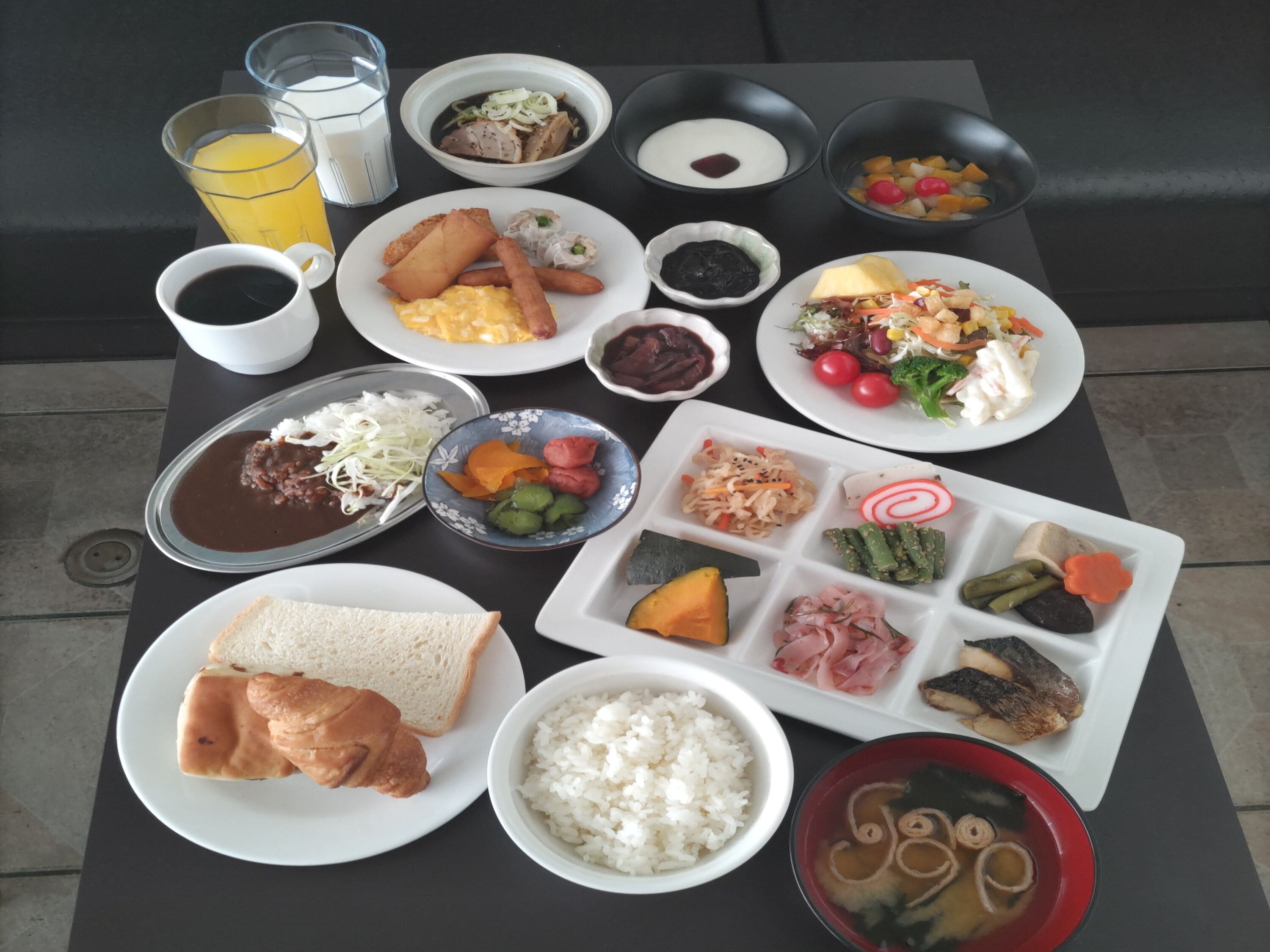 A table with various dishes including rice, soup, and vegetables.