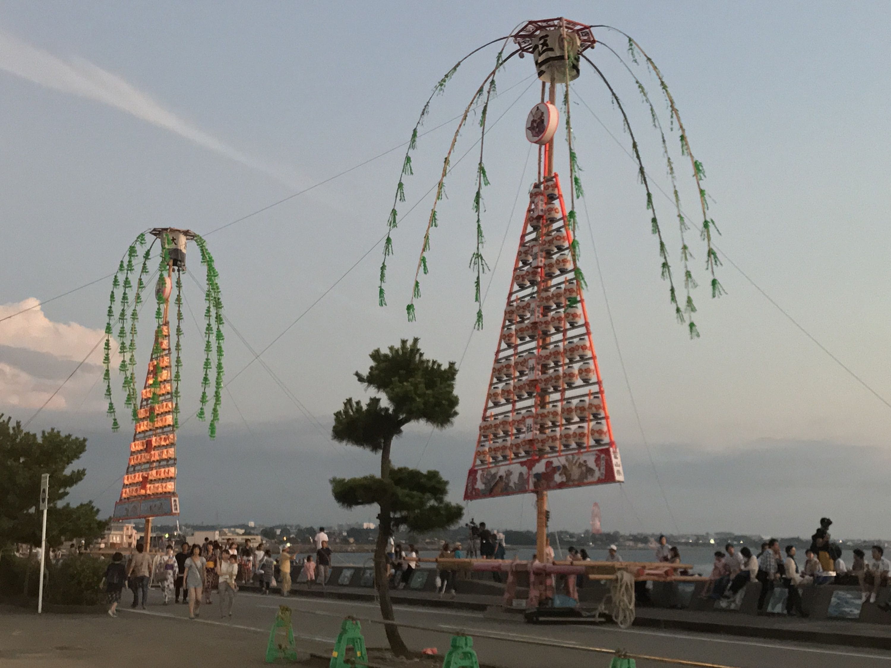 Una gran estructura al aire libre con varios niveles, decorada con elementos colgantes, rodeada de gente.