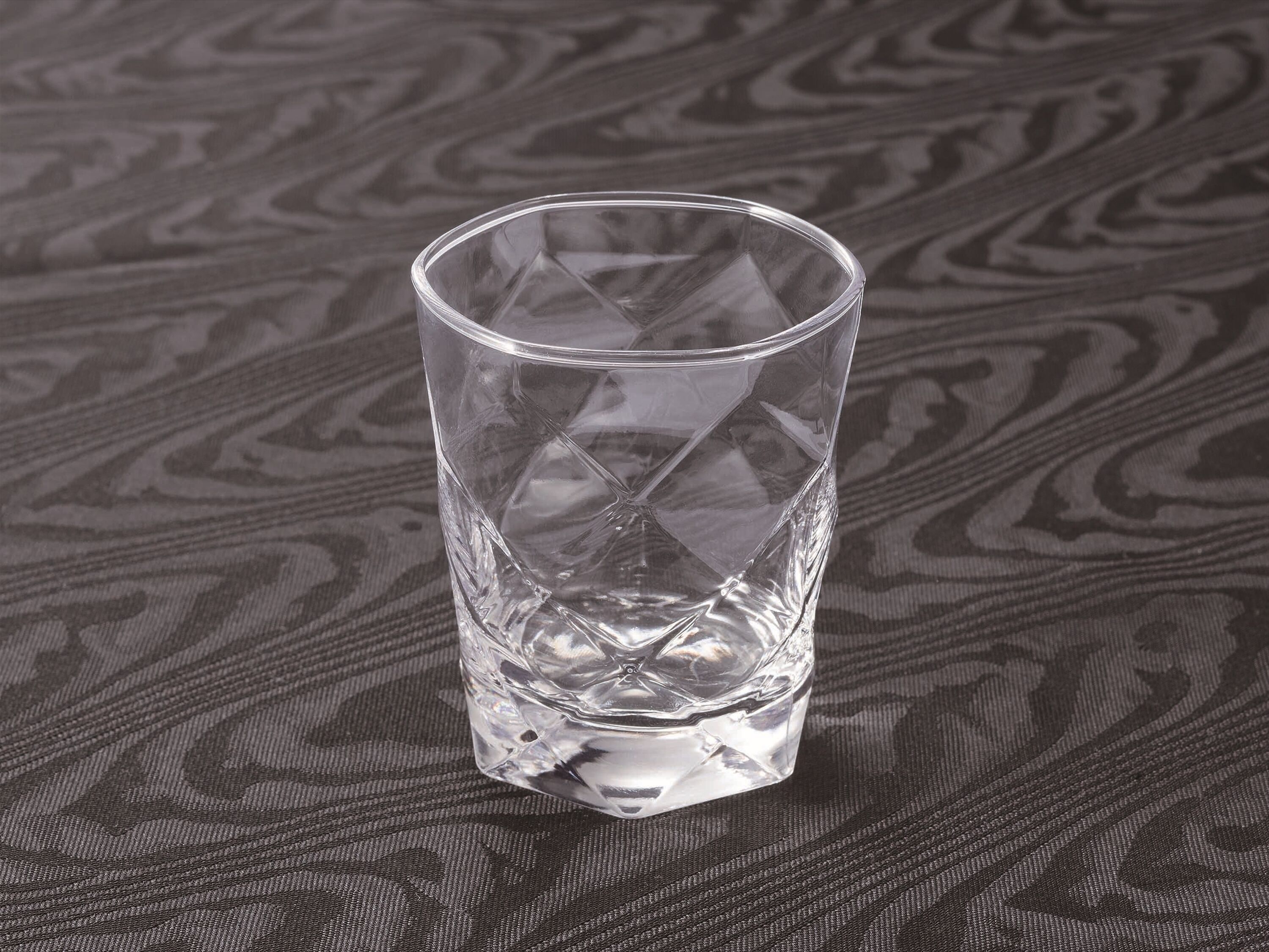 Un vaso transparente sobre una superficie con textura.