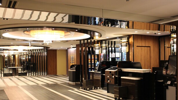 Un hall de hotel de diseño moderno, con una recepción, una araña y un mostrador de entrada.