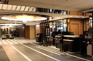 Un hall de hotel de diseño moderno, con una recepción, una araña y un mostrador de entrada.