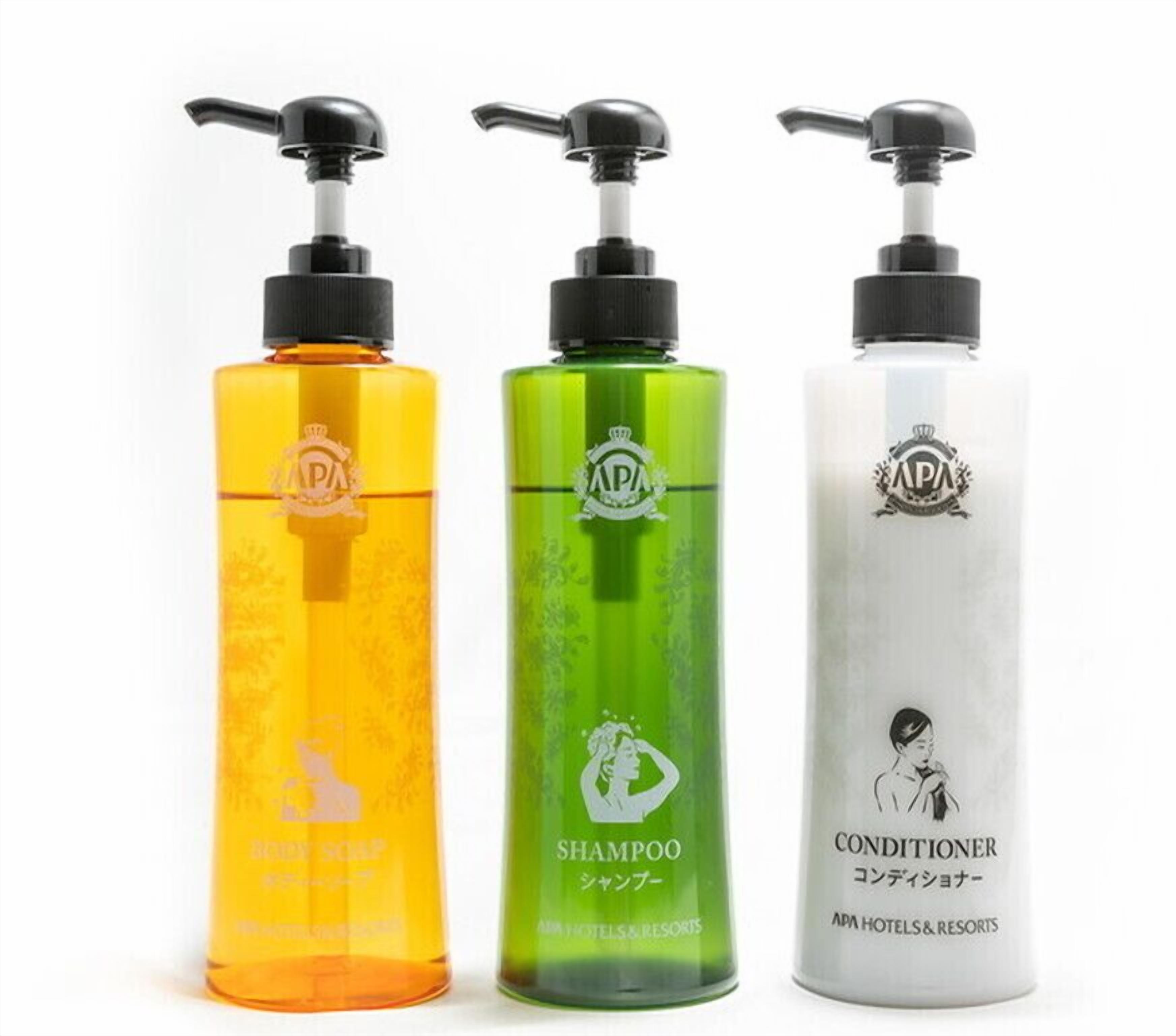 Three bottles of liquid with pumps, labeled as shampoo, conditioner, and another liquid product.