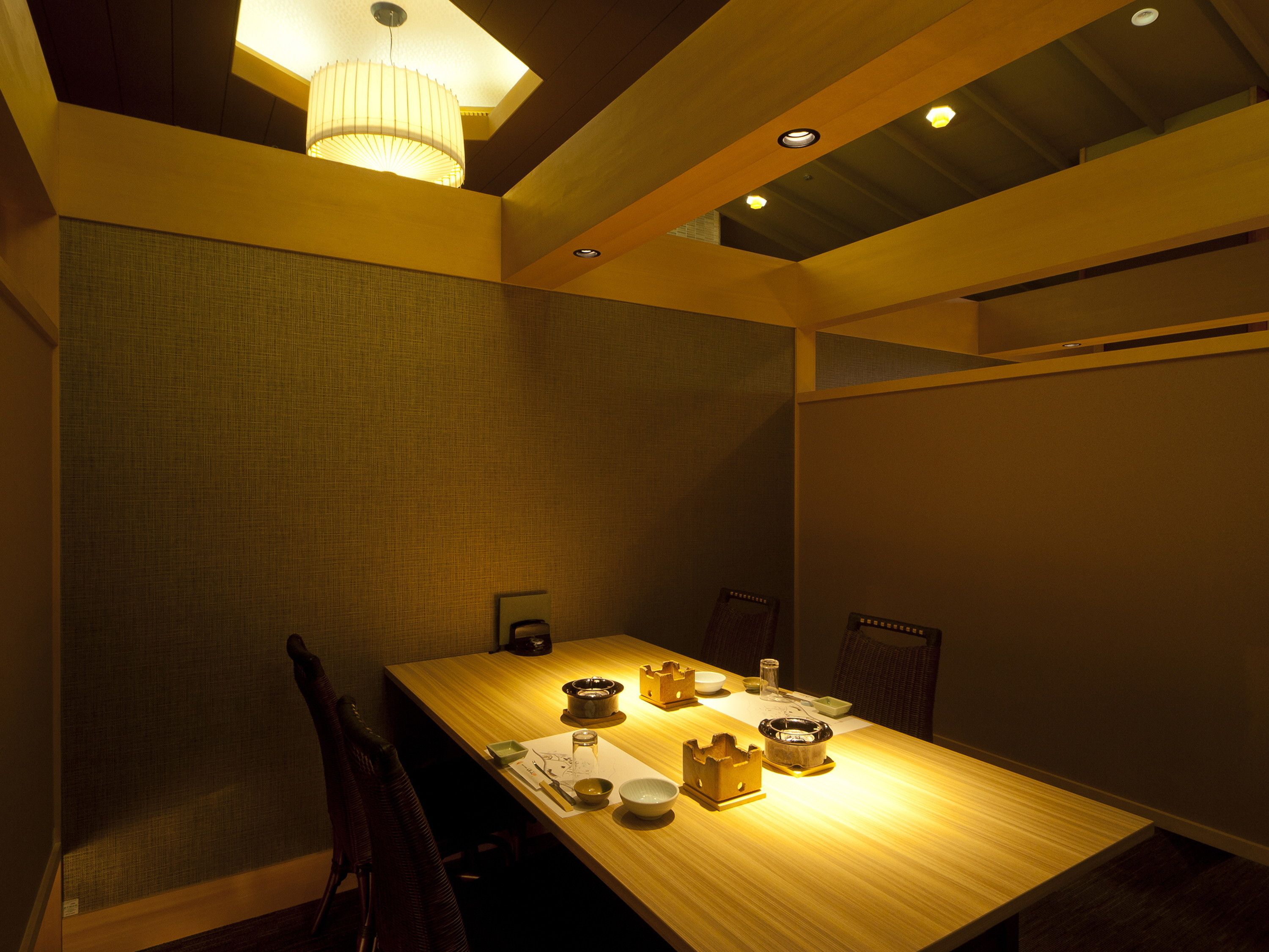 A dining area with a long wooden table, chairs, and a chandelier.