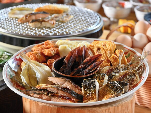 A variety of dishes including seafood, vegetables, and bread on a wooden table.