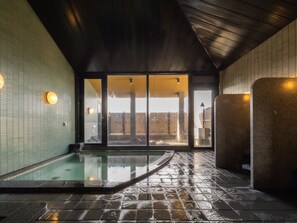 A spa area with a hot tub, tiled walls, and a wooden ceiling. - APA Hotel Kagadaishoji Ekimae (Kaga)