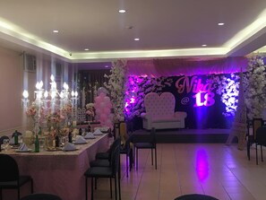 A decorated event space with a stage, floral arrangements, and a seating area. - NS Royal Hotel -city Center Cebu (Cebu City)