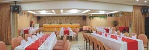 A banquet hall with tables set for events, a stage, and a speaker system. - NS Royal Hotel -city Center Cebu (Cebu City)