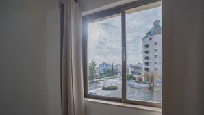 A window with a view of a cityscape, including buildings and a road. - Algardia Apartments (Loulé)