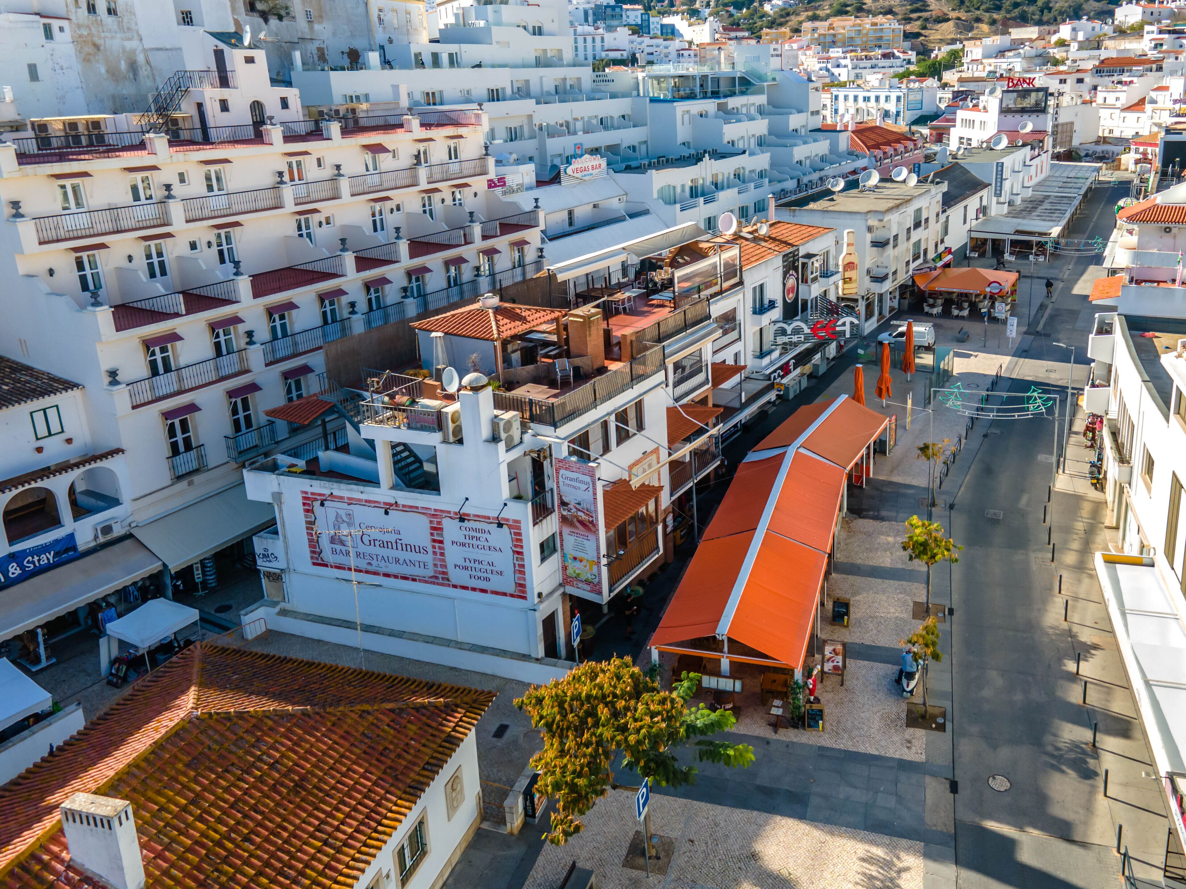A coastal town with white buildings, a bar, and a restaurant.