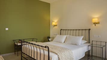 A bedroom with a bed, bedside tables, a chair, and wall-mounted lamps.