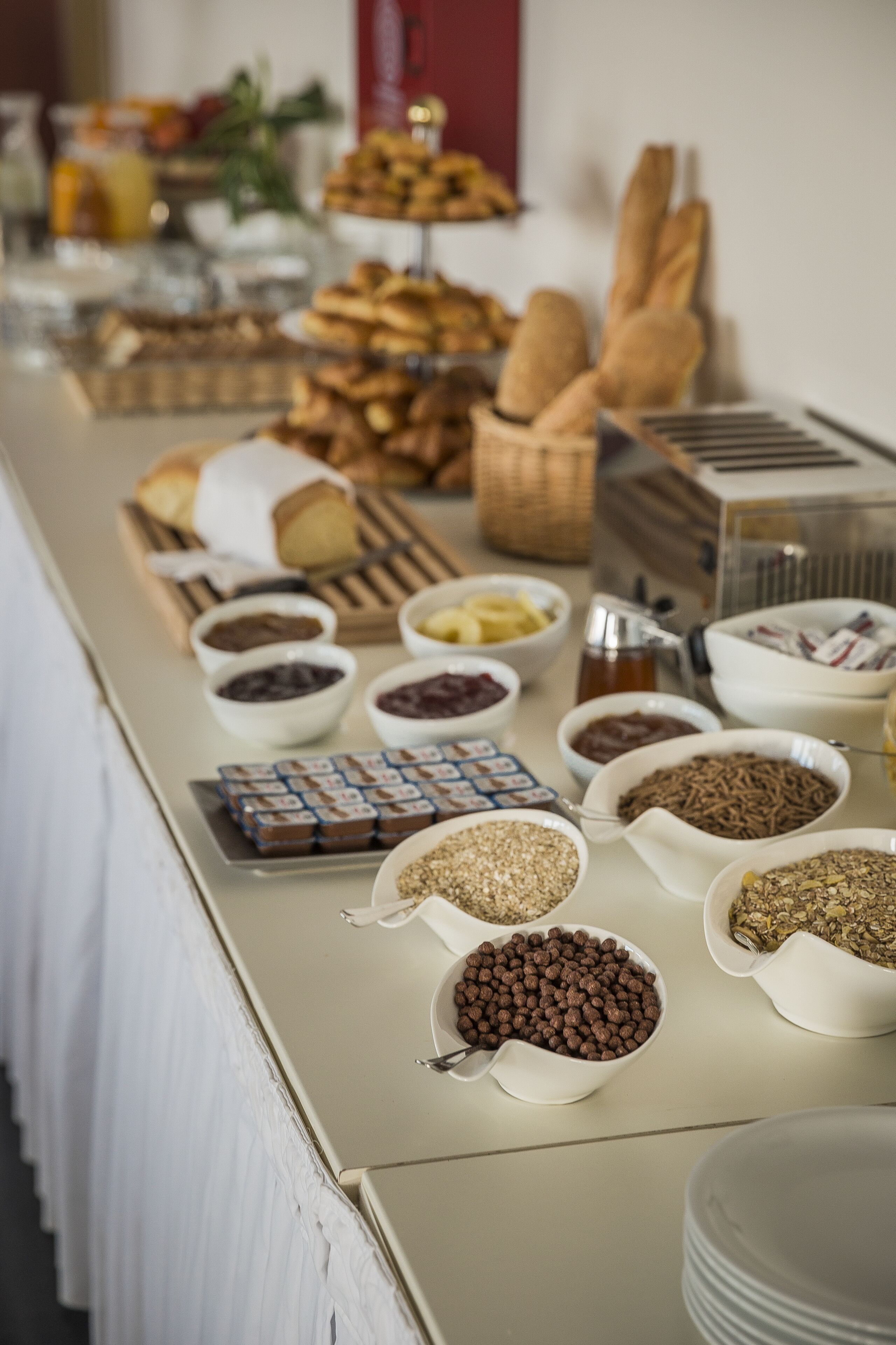 A buffet table with various food items and condiments.