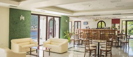 Un'ampia hall con area bar, posti a sedere e grandi finestre con vista.