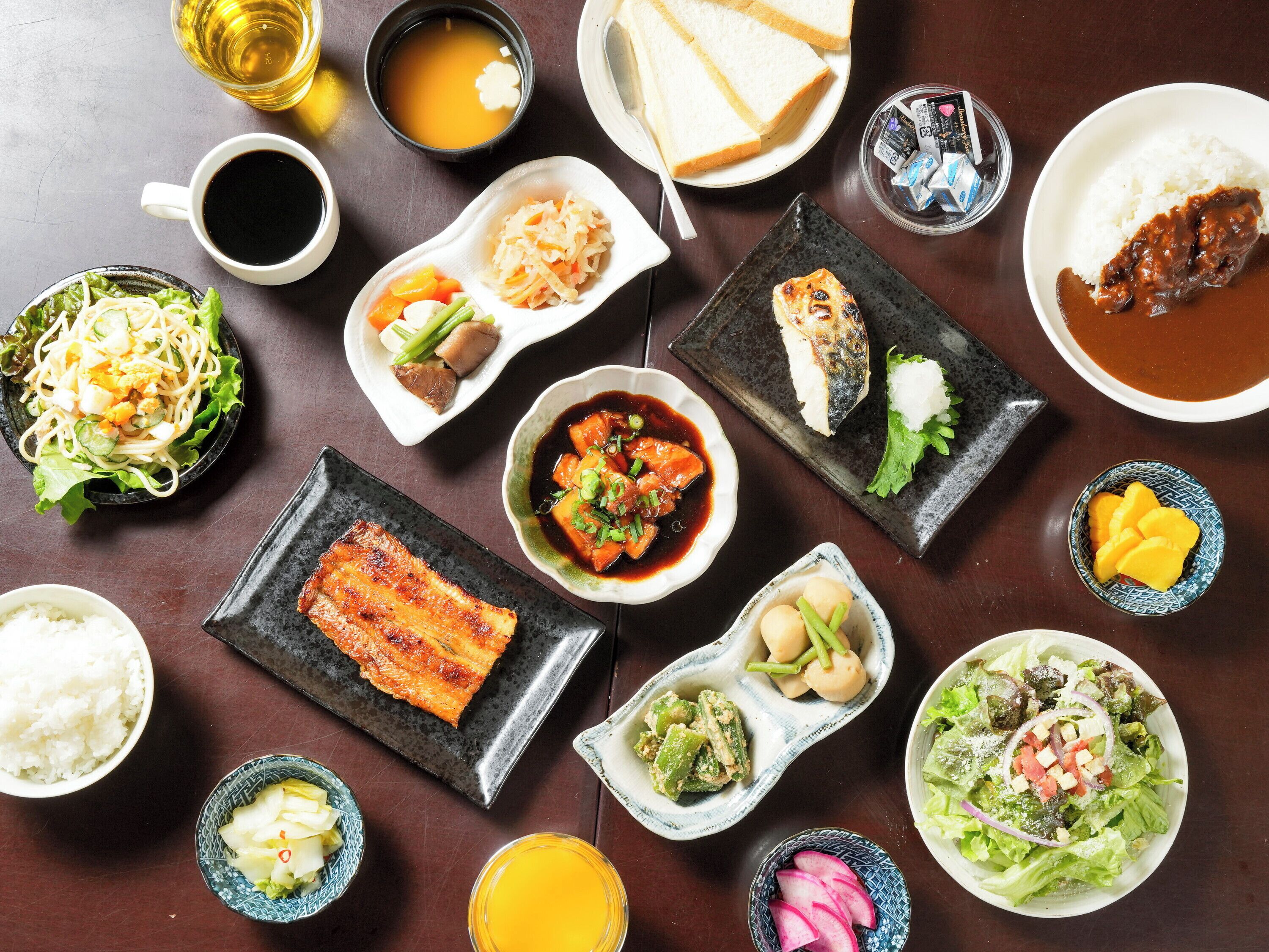 Variedad de platos japoneses, incluyendo sushi, sashimi y bowls de arroz, dispuestos sobre una mesa de madera.
