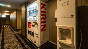 Ein Getränkeautomat mit der Aufschrift 'KIRIN' und ein Eismaschine in einem Hotelgang.