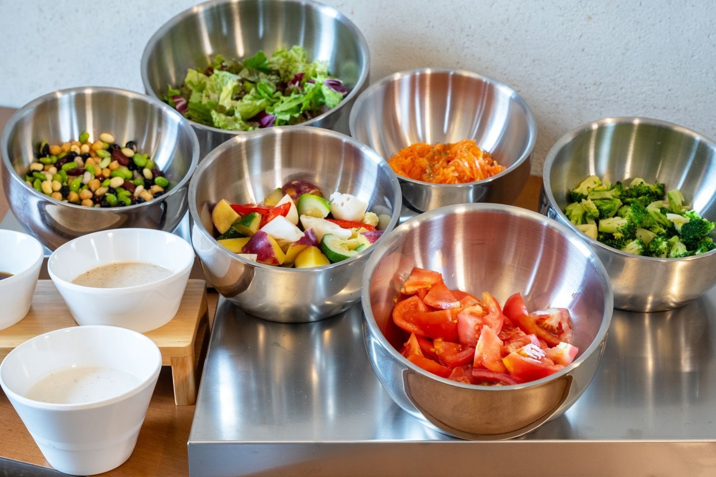 Various metal bowls containing different food items on a kitchen counter.