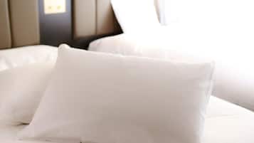 Una cama con ropa blanca y cabecera.