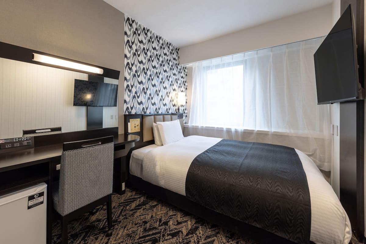 Luxe beddengoed, donzen dekbedden, een bureau, verduisterende gordijnen
