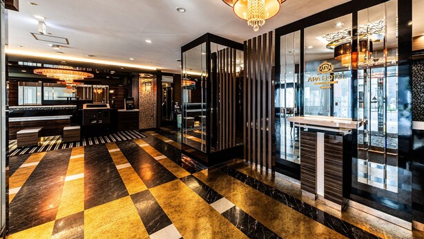 Eine Hotelhalle mit Check-in-Schalter, Rezeption und einer Kronleuchter.