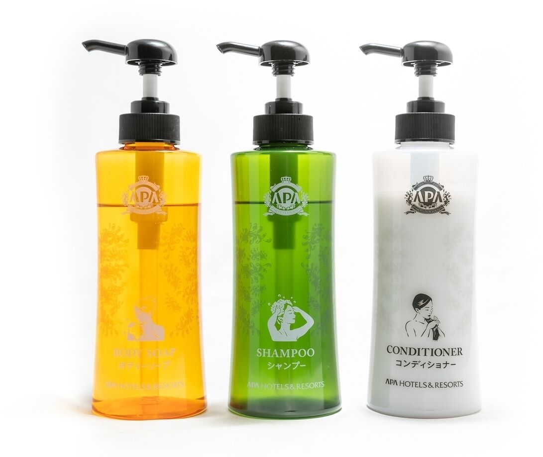 Three bottles of body care products: body soap, shampoo, and conditioner.