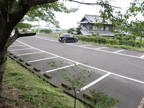 Park alongside a traditional Japanese-style building with a tiled roof.