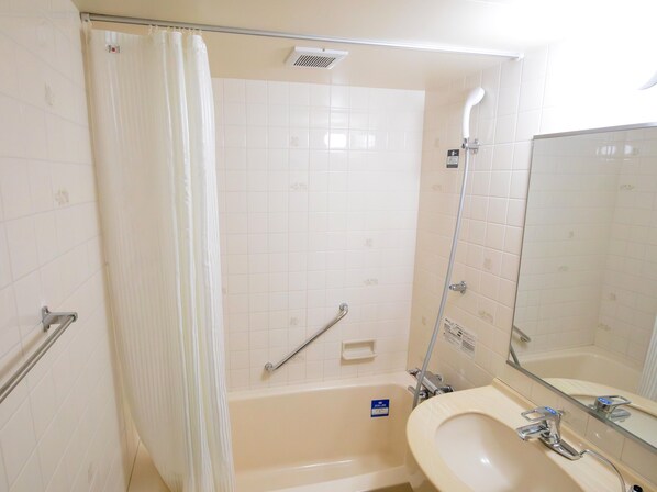 Un baño con bañera, ducha, inodoro y lavabo con espejo.