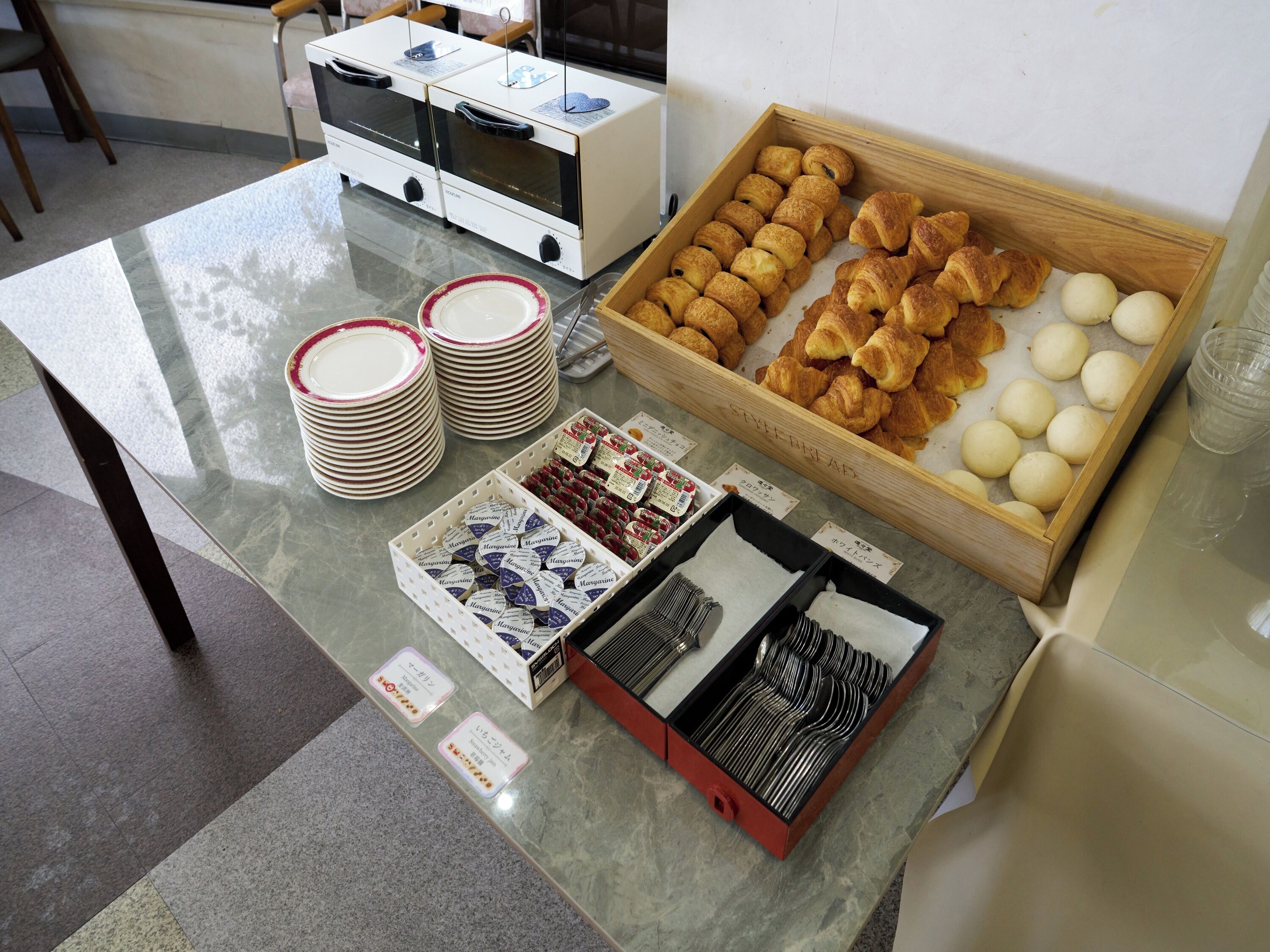 Un buffet de petit-déjeuner avec des croissants, des petits pains et diverses garnitures.